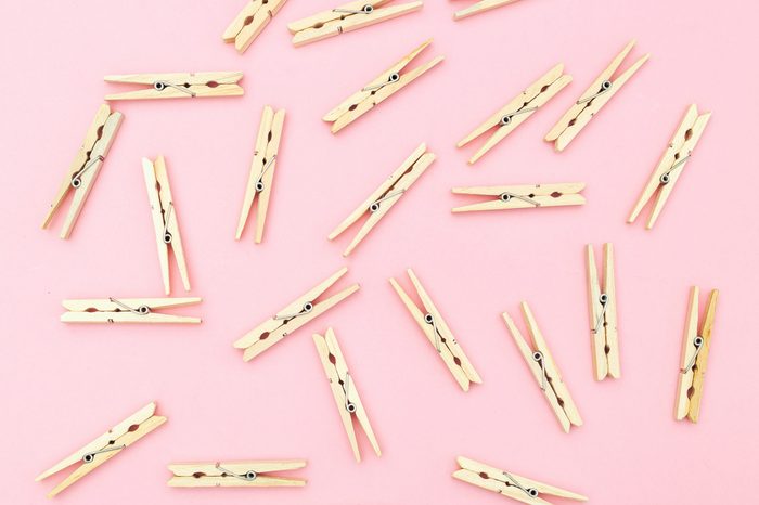 Wooden clothes pegs on pink background. Zero waste
