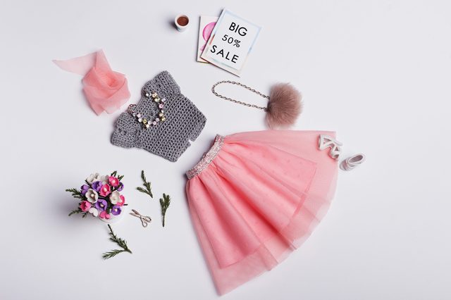 Doll clothes laid out, featuring gray knit top and pink tulle skirt; surrounded by accessories and flowers. Card reads "BIG 50% SALE".