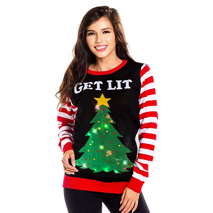 Woman wears a festive sweater displaying a lit Christmas tree and text "GET LIT," paired with red and white striped sleeves.