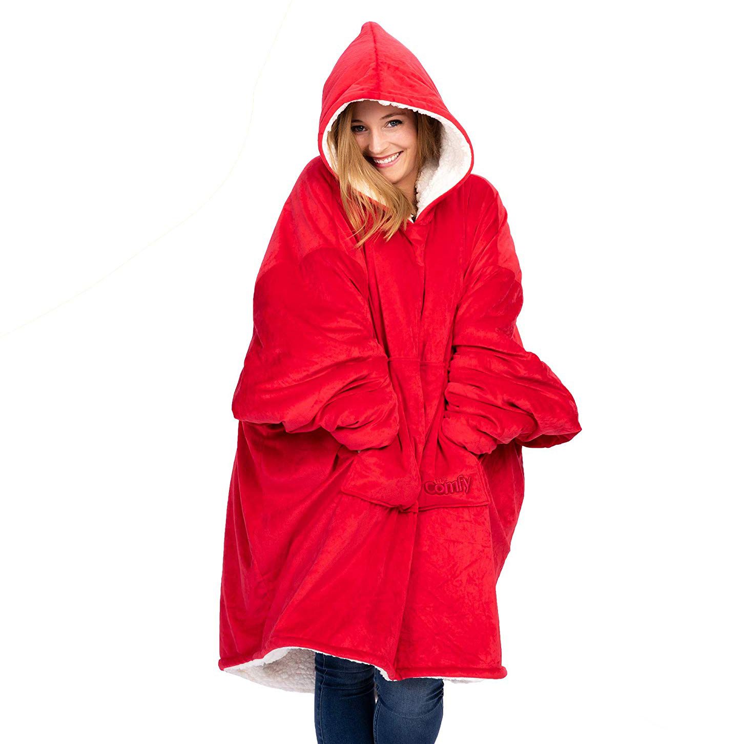 Person wearing oversized red hoodie, smiles warmly, standing against a plain white background.