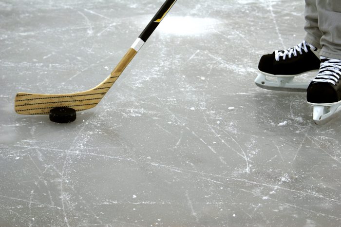 a hockey stick and puck and ice skates on the ice