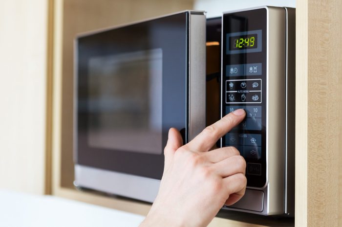 Detail of male hand while using the microwave