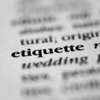 The word "etiquette" in bold text is highlighted in a dictionary, surrounded by partially visible blurred words.