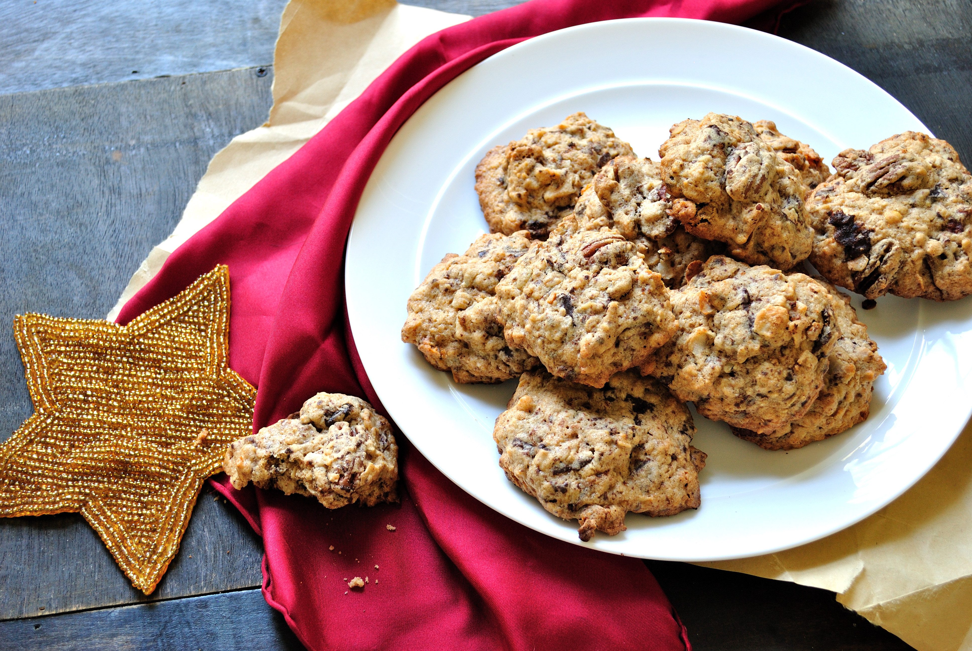 Cookies rest on a white plate, atop a red cloth, with a decorative star and wooden table providing the backdrop.