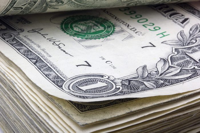 United States one dollar bill laying in a stack of money.