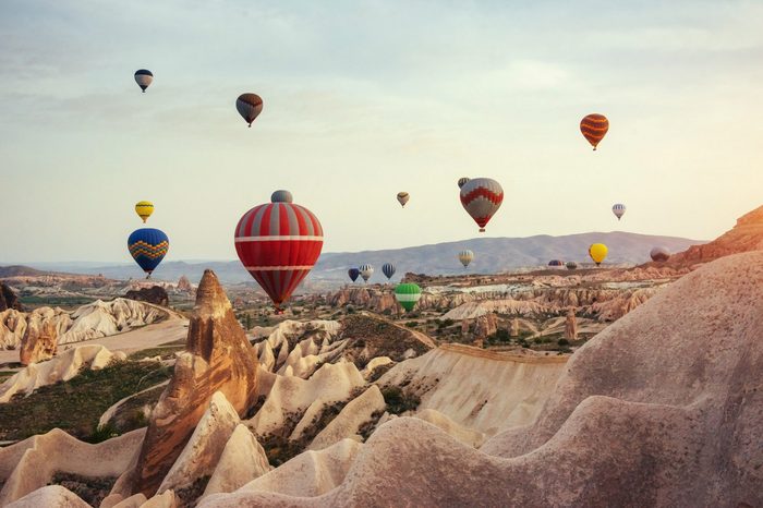 Hot air balloon flying over rock landscape at Cappadocia Turkey.