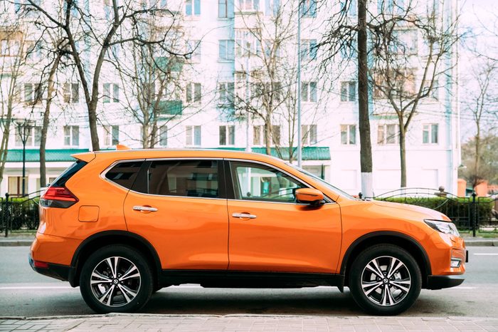 Orange Nissan X-Trail third generation Car Parked At Street. Side View