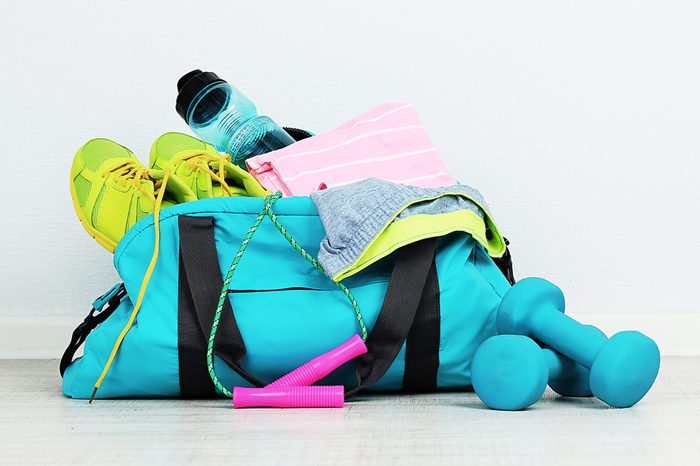 Sports bag with sports equipment in room