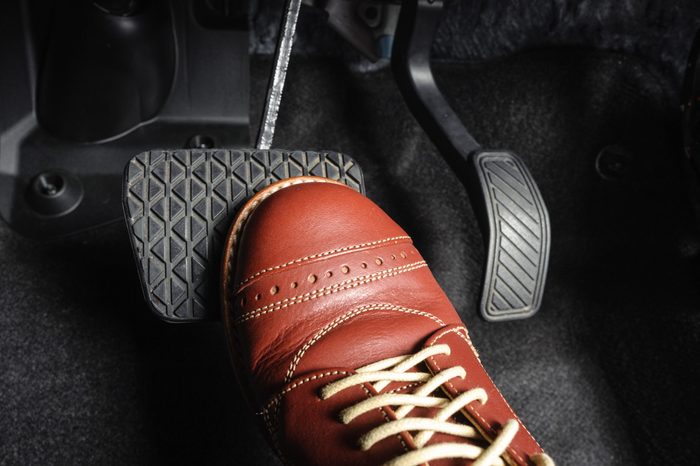 foot pressing the brake pedal of a car