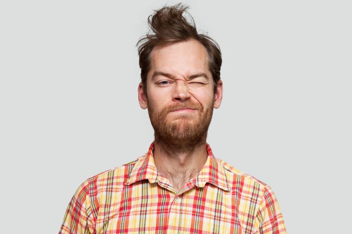 portrait of a disheveled man. gray background.