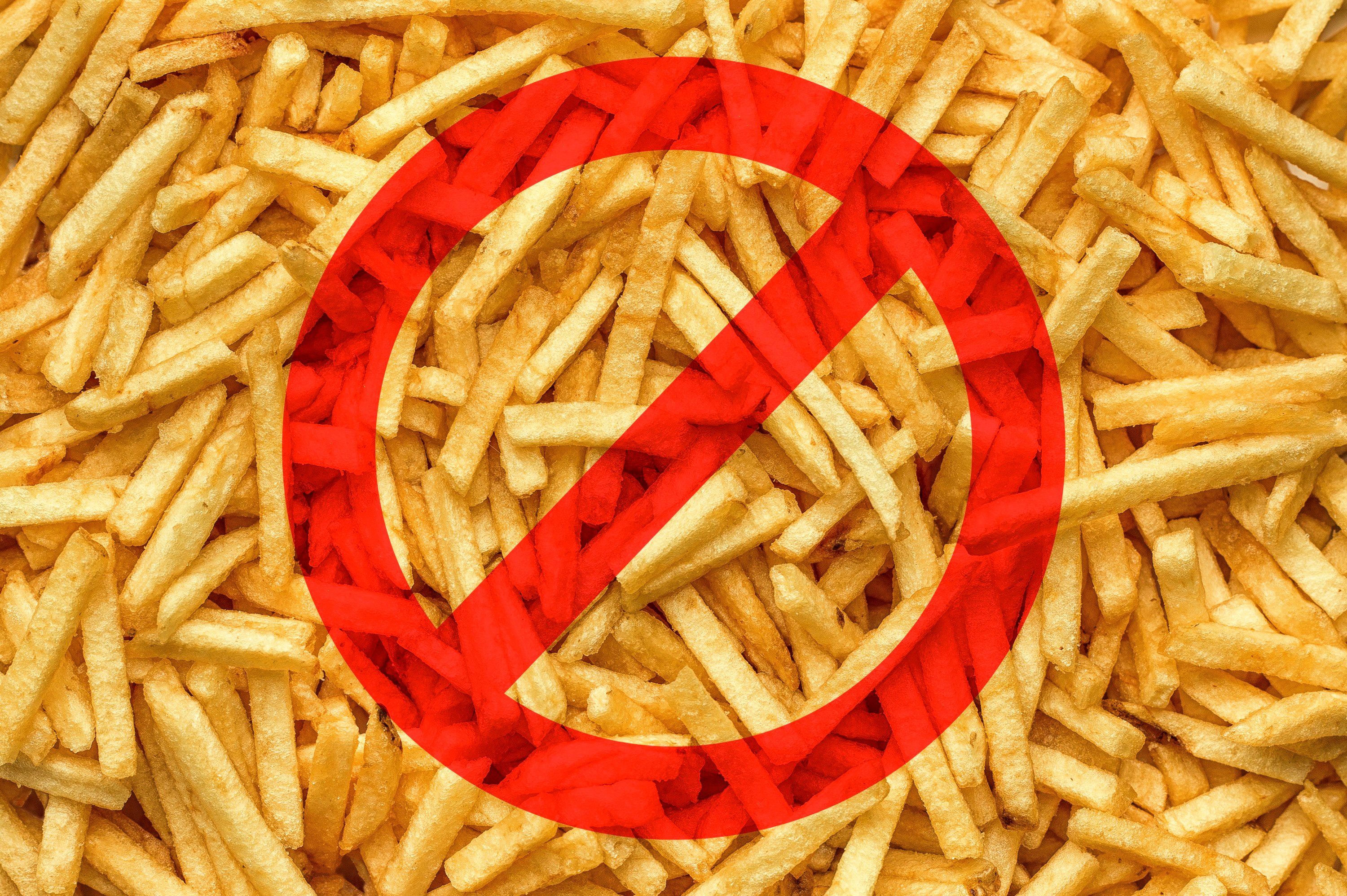 Fries are shown with a red prohibition sign overlayed, indicating restriction or ban.
