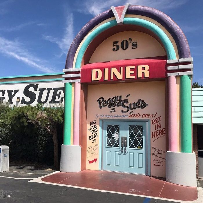 Diner entrance with retro design features colorful pastel columns. Sign reads 