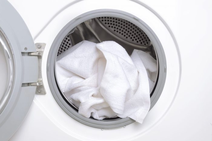 Finishing a part house, washing the white towels.Closeup of washing machine drum