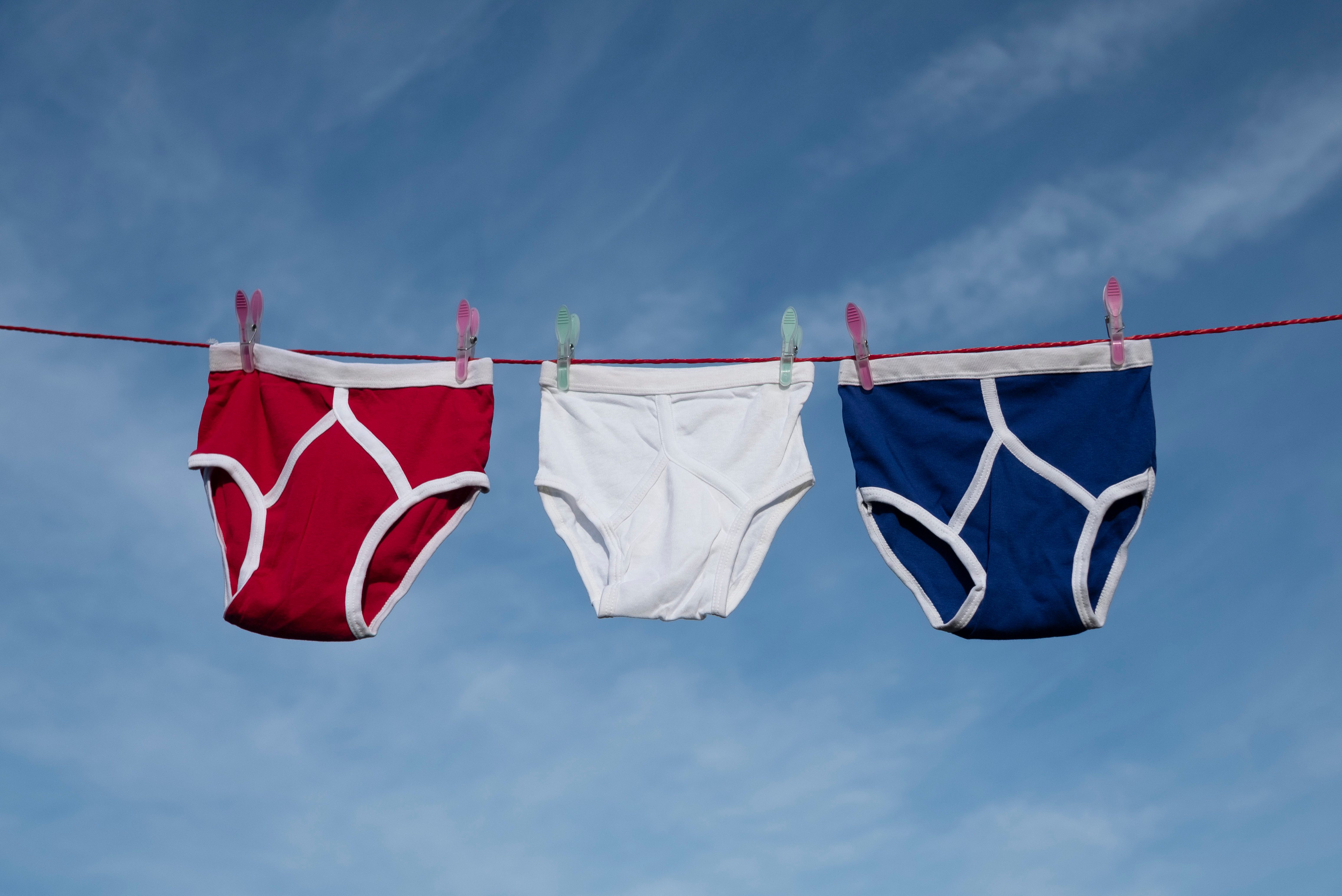 red, white and blue retro Y-Front underpants on a washing line against a blue sky.
