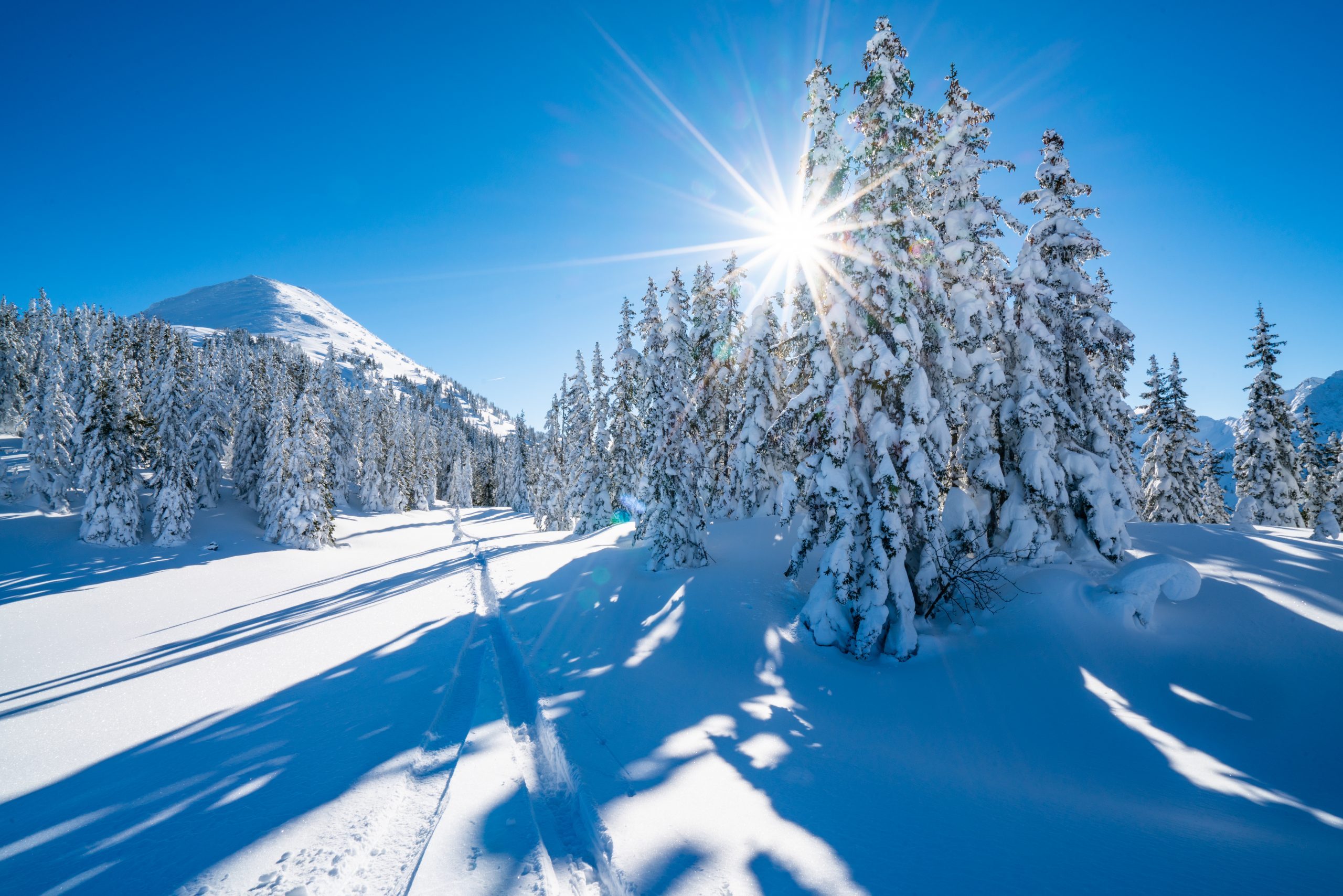 star shape sun in snowcapped winter mountain landscape