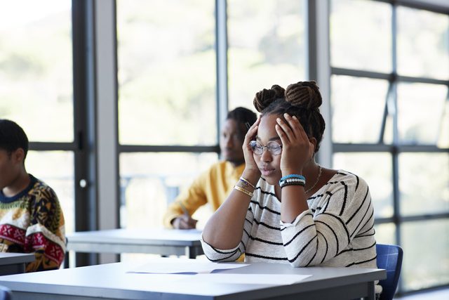 Worried student sitting with head in hands at desk