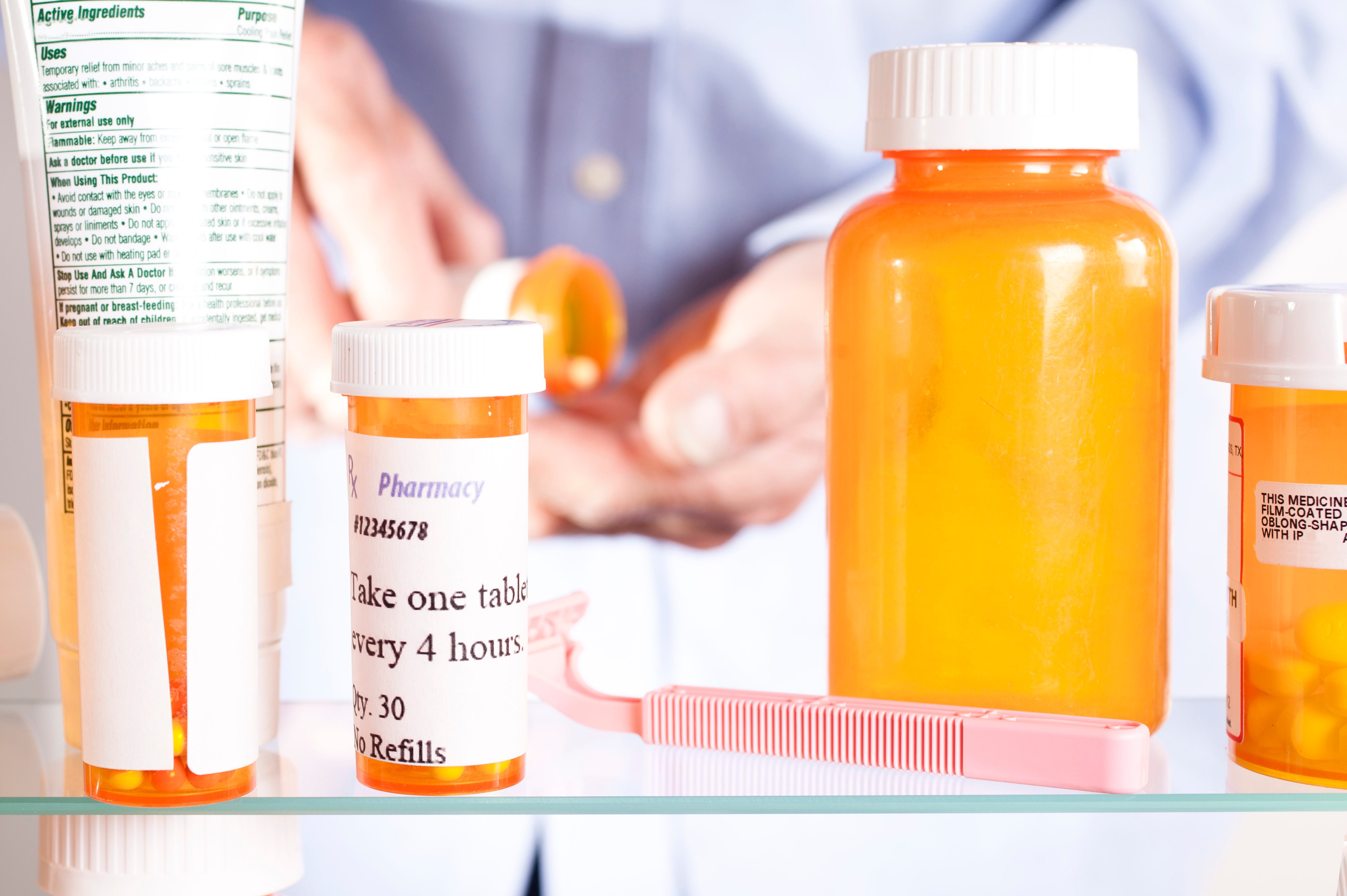 Senior adult man gets prescription medicines out of cabinet.