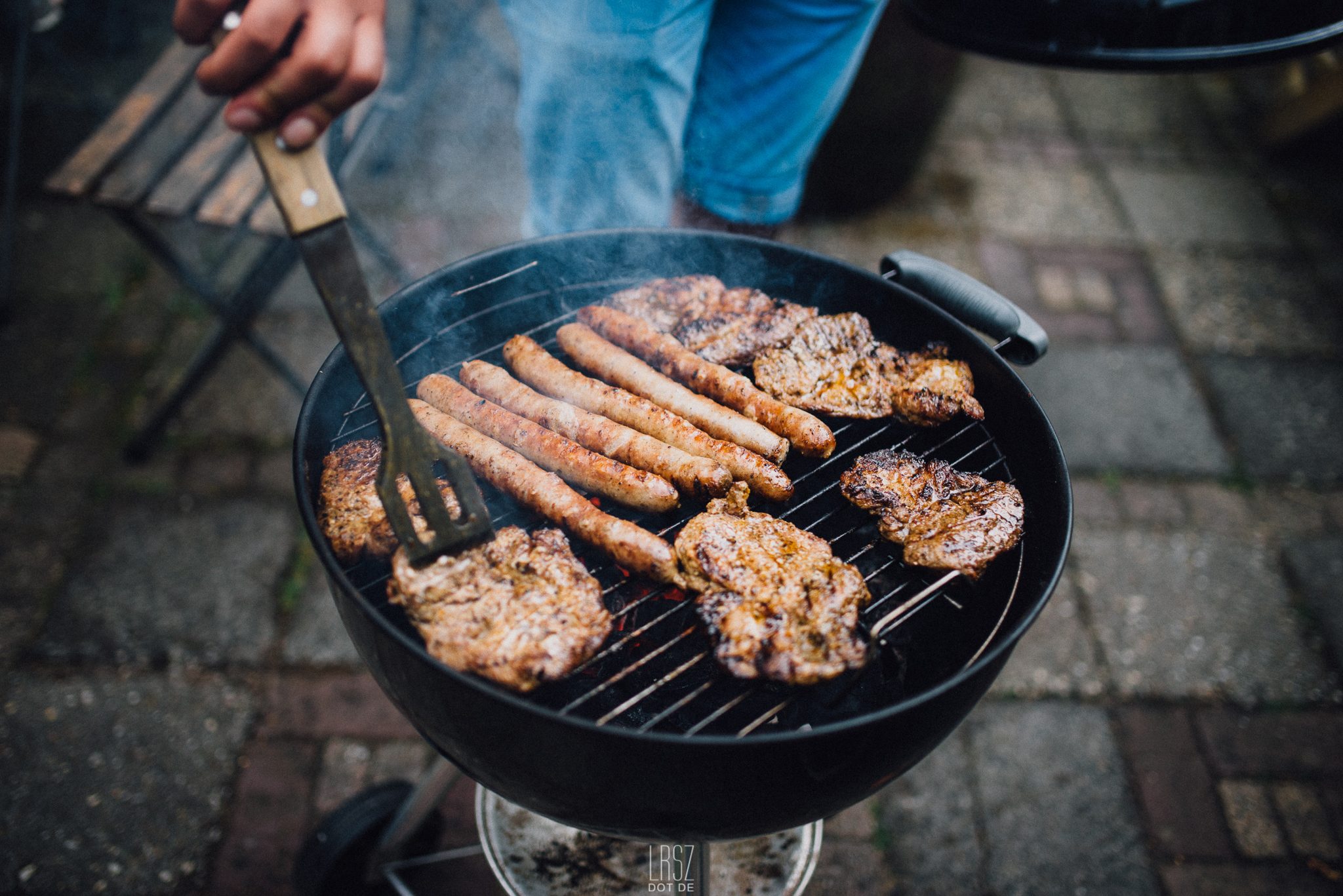 Man Preparing Food On Barbecue Grill
