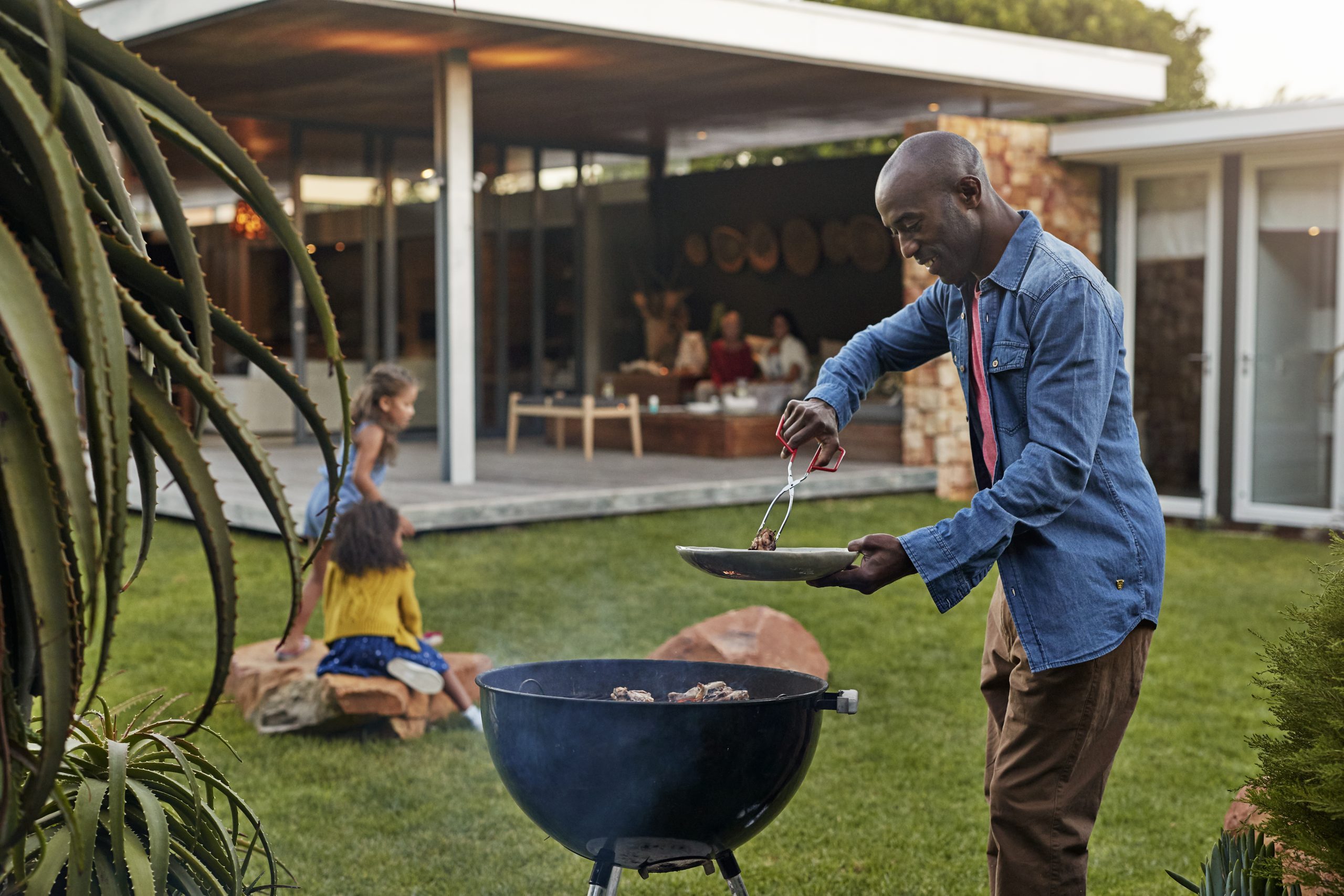 Family cooking on grill in their garden