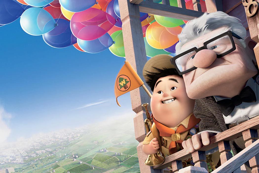 Two animated characters fly in a house lifted by colorful balloons, overlooking a green landscape. One holds a flag, smiling.