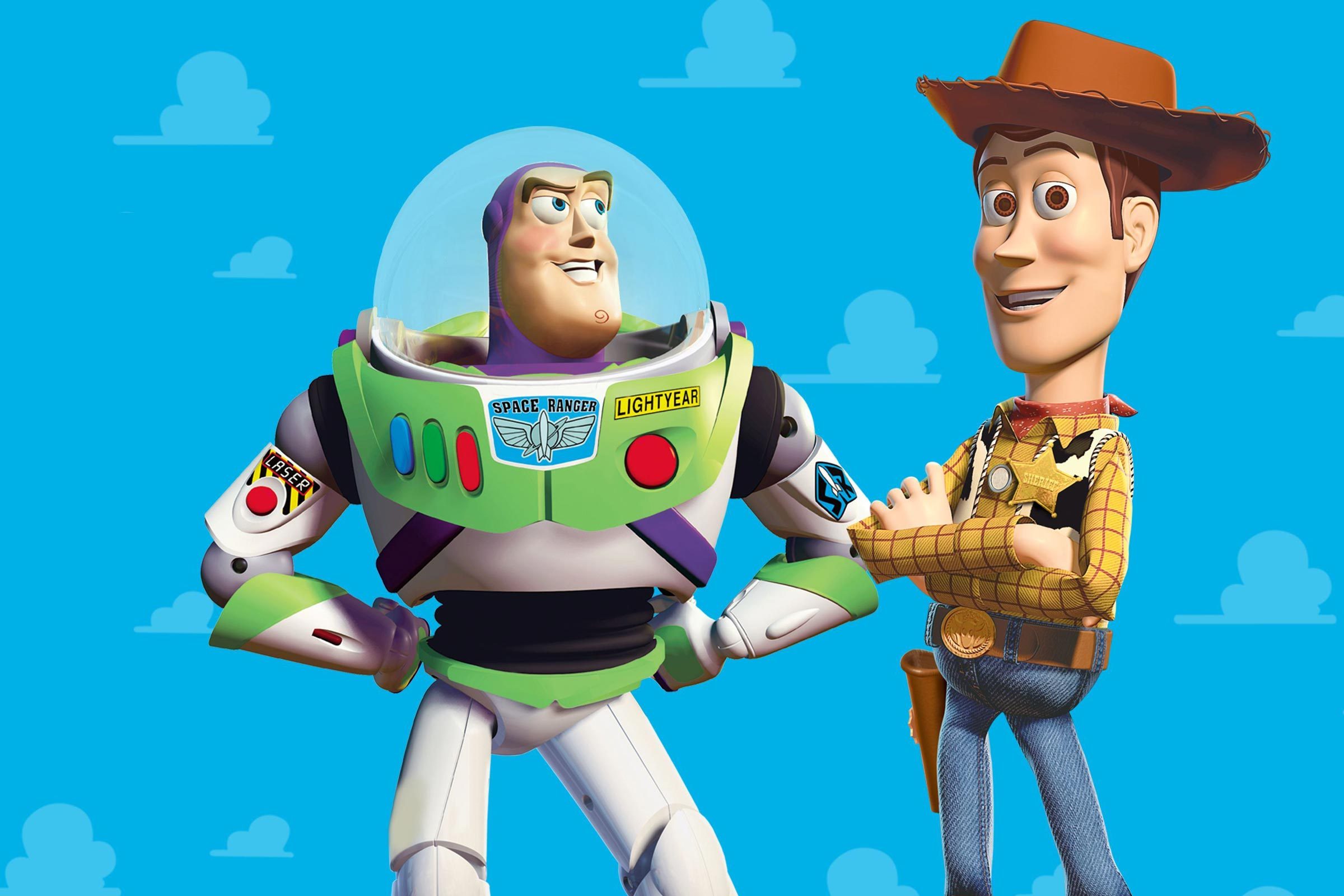 A space ranger and cowboy toy stand smiling, with hands on hips against a blue background with clouds.