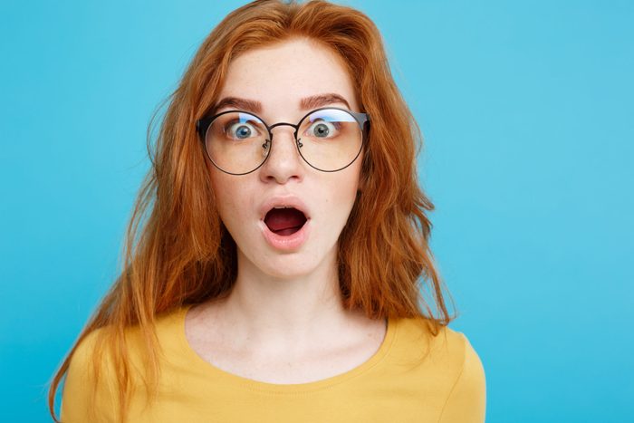 Portrait Of Shocked Woman Against Blue Background