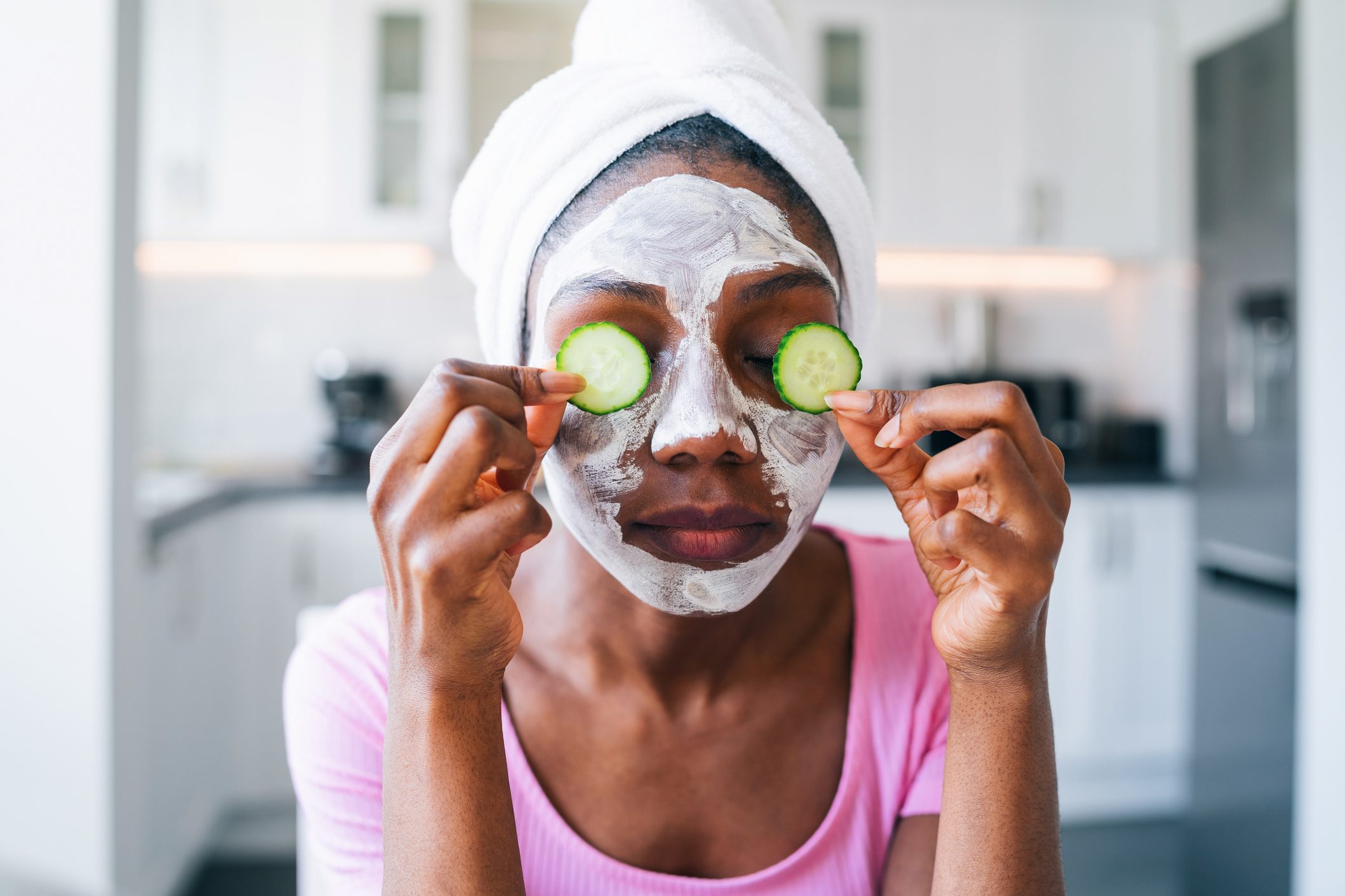 Beautiful young afro woman with cucumber on eyes