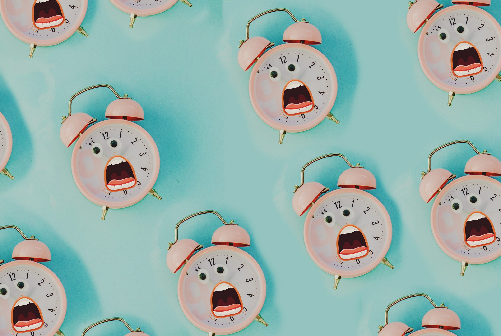 Pink alarm clocks with googly eyes and cartoon mouths, appearing surprised, are arranged on a turquoise background.