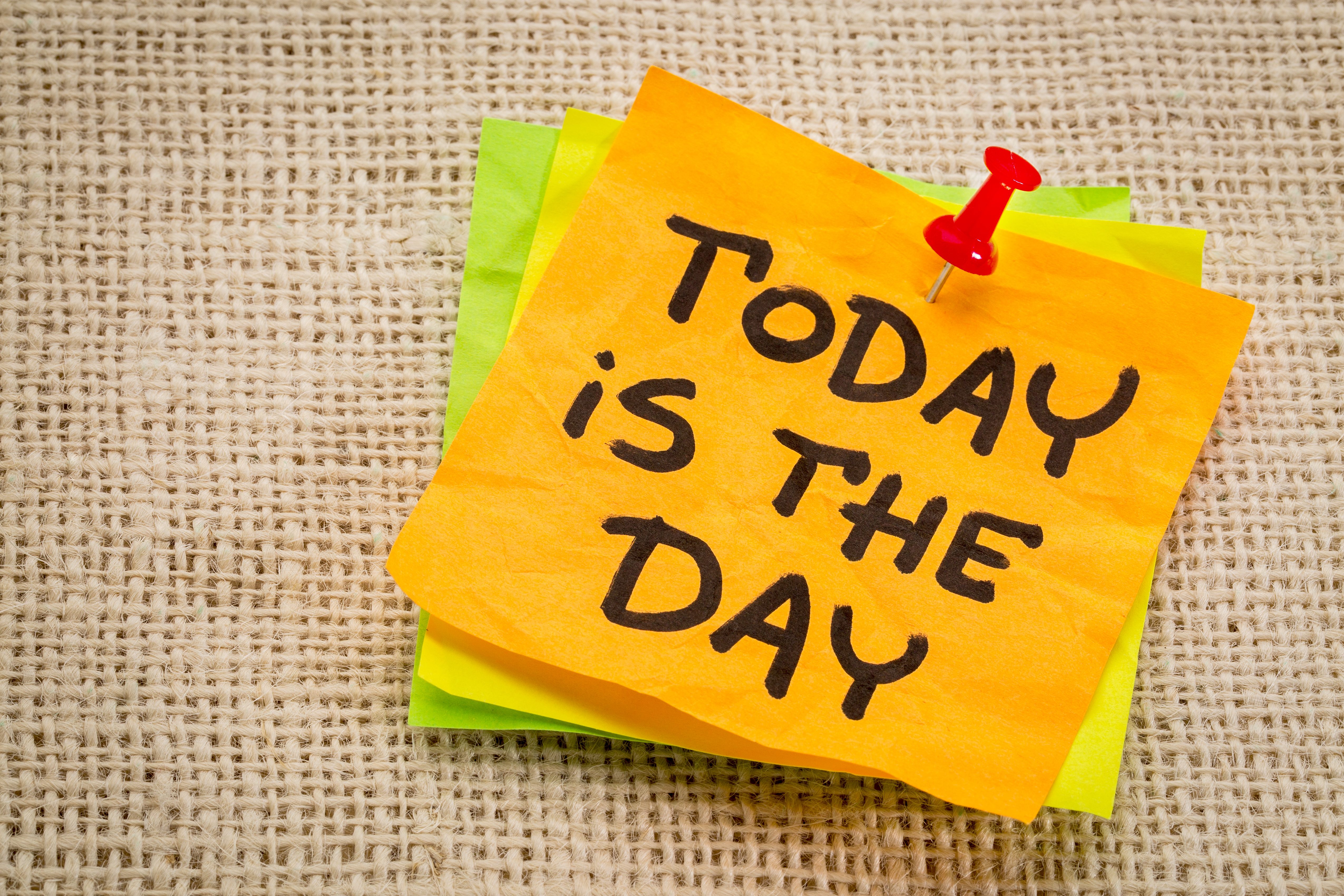 A yellow sticky note, pinned with a red pushpin, displays "TODAY is THE DAY" on textured burlap.
