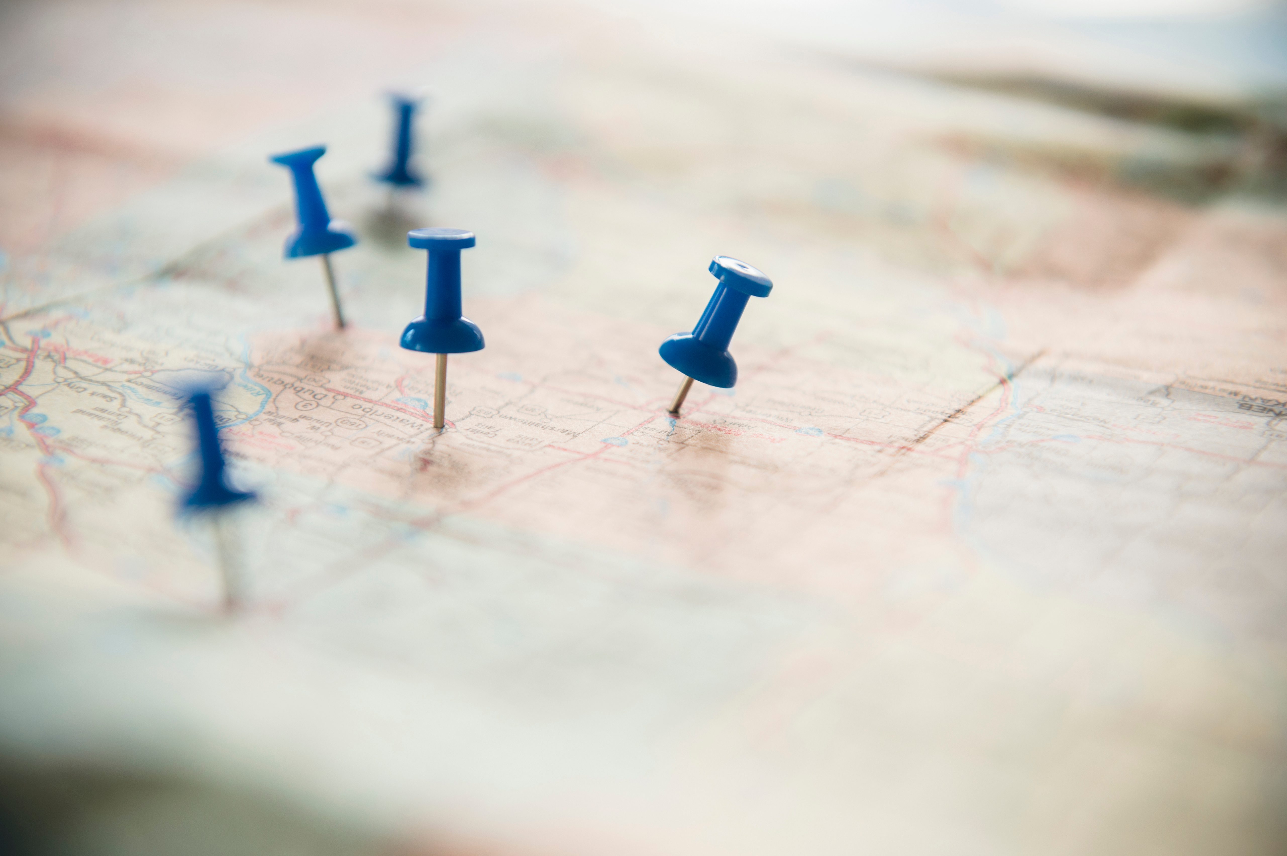 Blue push pins mark locations on a large, unfolded map.