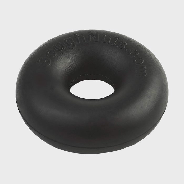 Black rubber dog toy donut laying on a plain gray background with embossed text 
