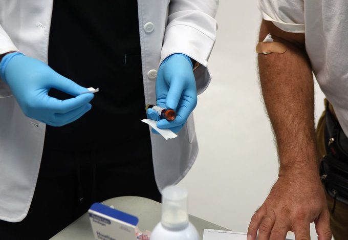 close up of health care worker taking blood sample for coronavirus antibody testing