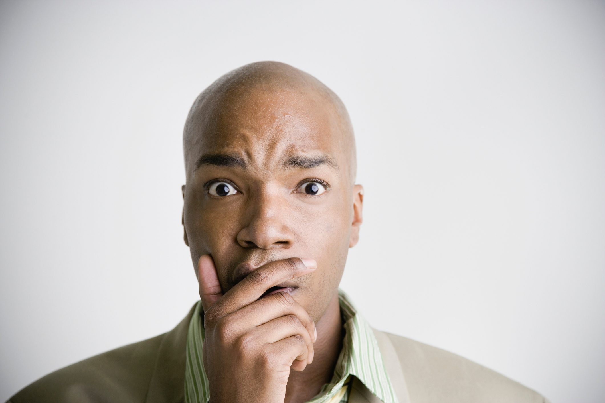 African businessman with hand covering mouth and chin