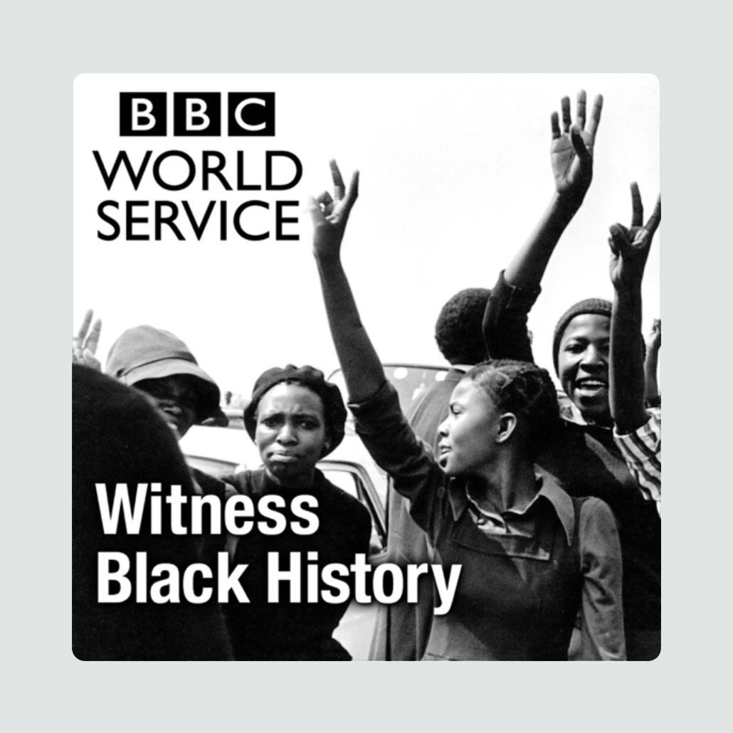 People raise hands, smiling, in a black-and-white photograph. Text reads "BBC World Service Witness Black History." Background includes others and indistinct environment.