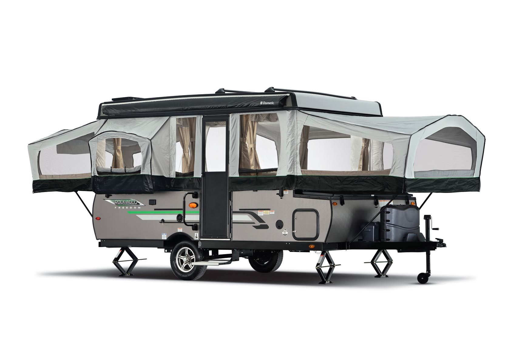 Camper trailer with extended pop-up sections stands on jacks, showcasing windows and door; logo reads "Rockwood Freedom."