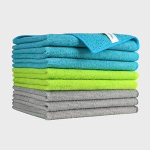 Stacked microfiber towels, depicting three colors: turquoise, yellow, and gray, with a visible label on the top towel, set against a plain background.