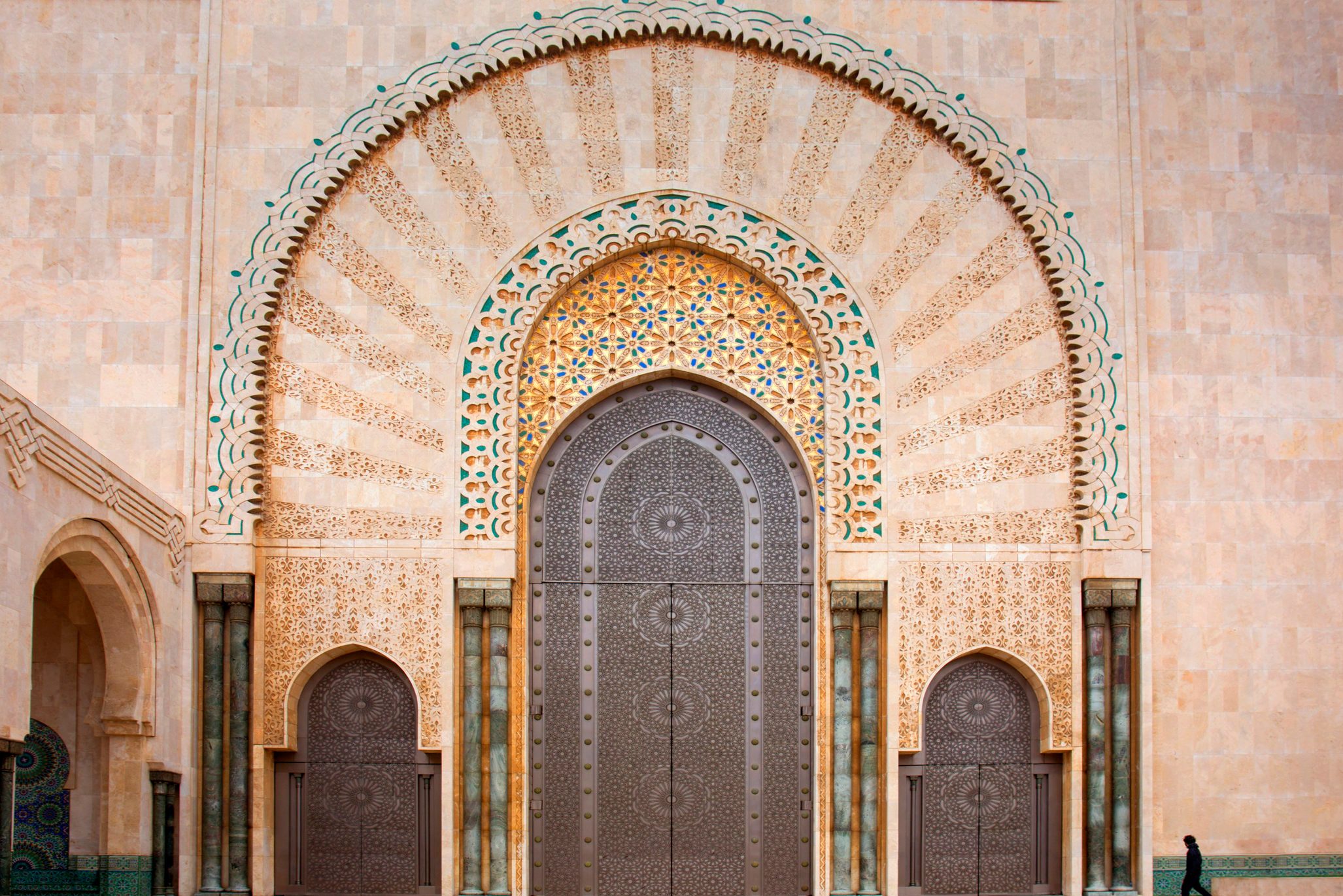 Man passing main entrance to mosque.