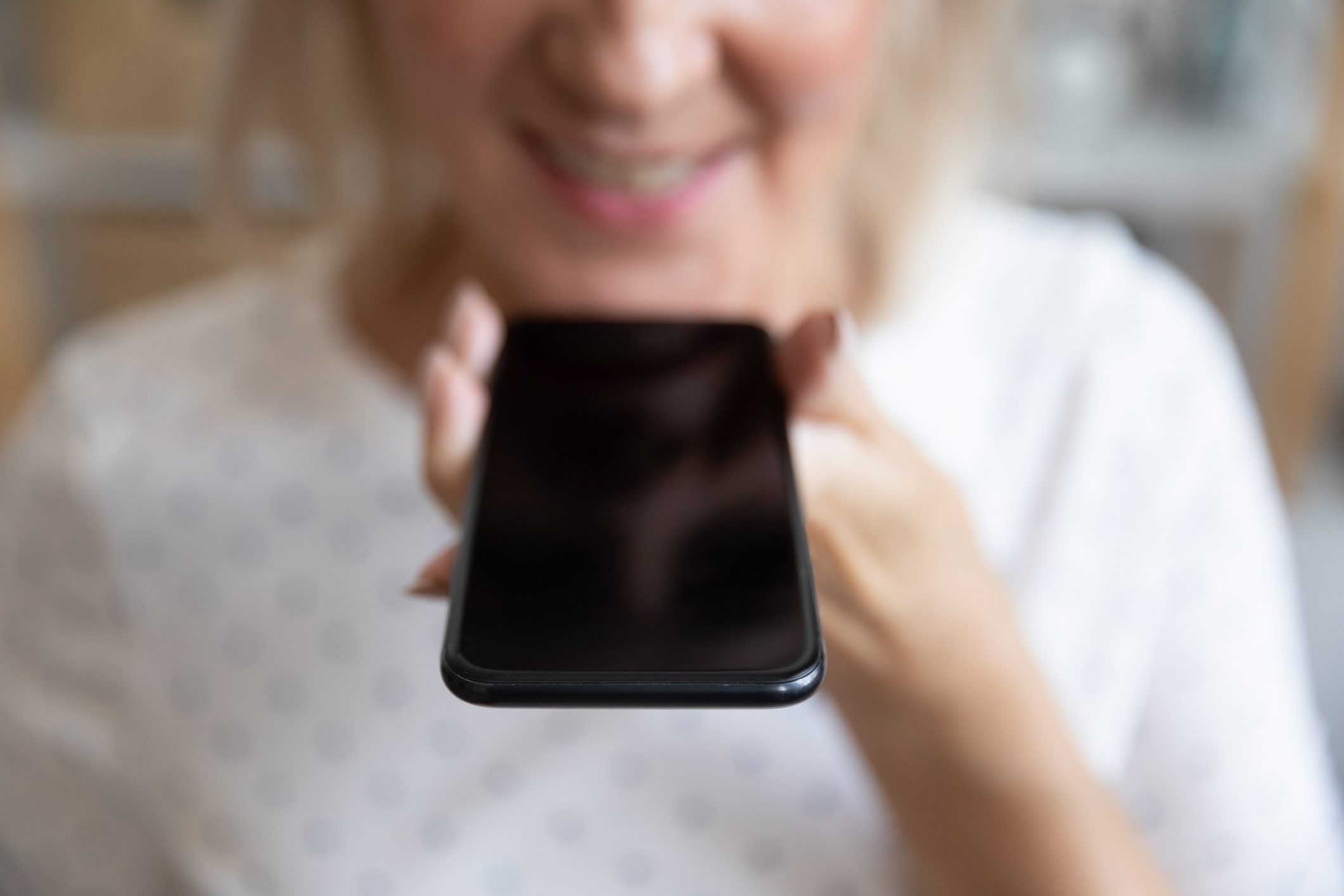 Close up mature woman holding phone, recording voice message