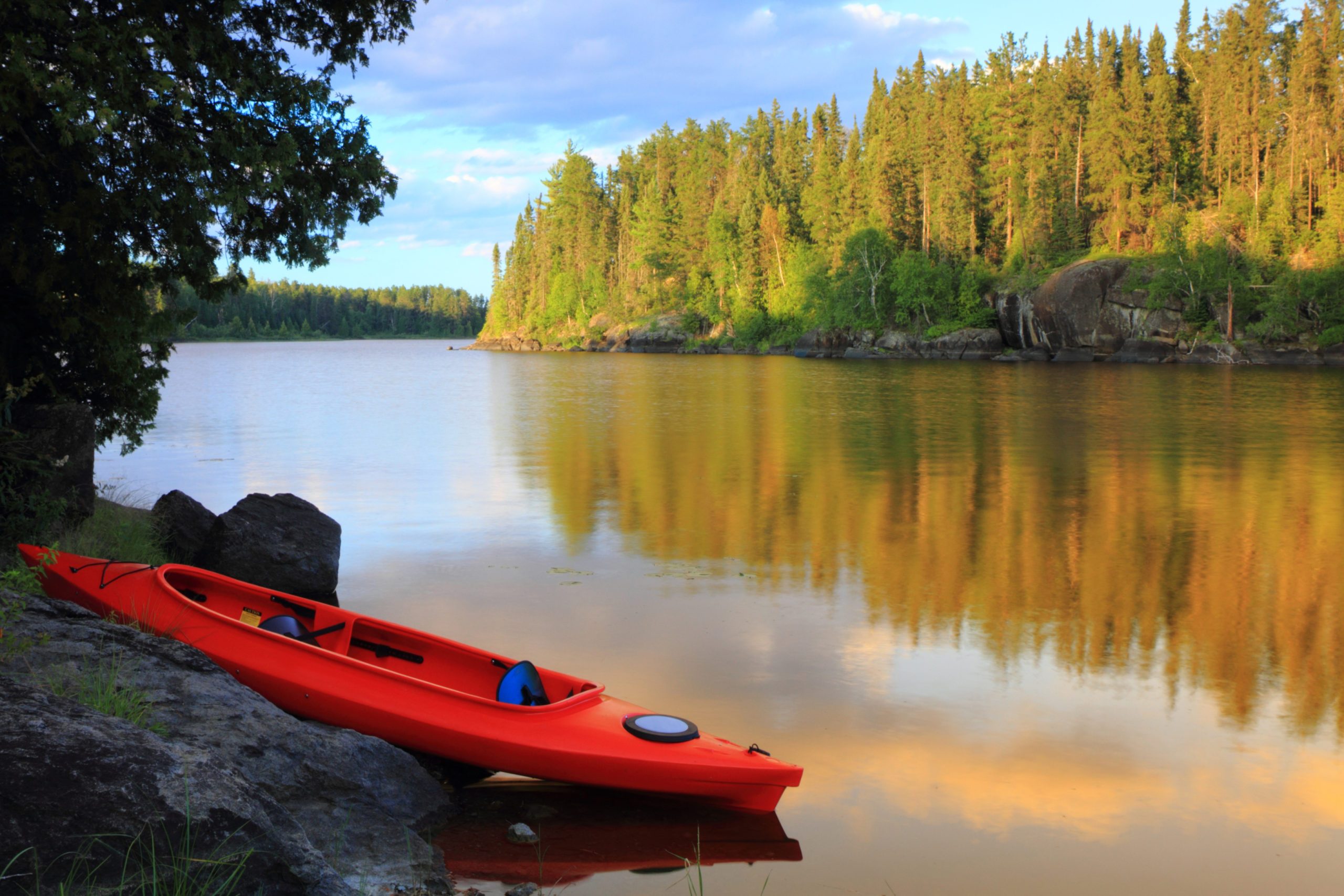 A red kayak at the lake on a lovely day in minnesota