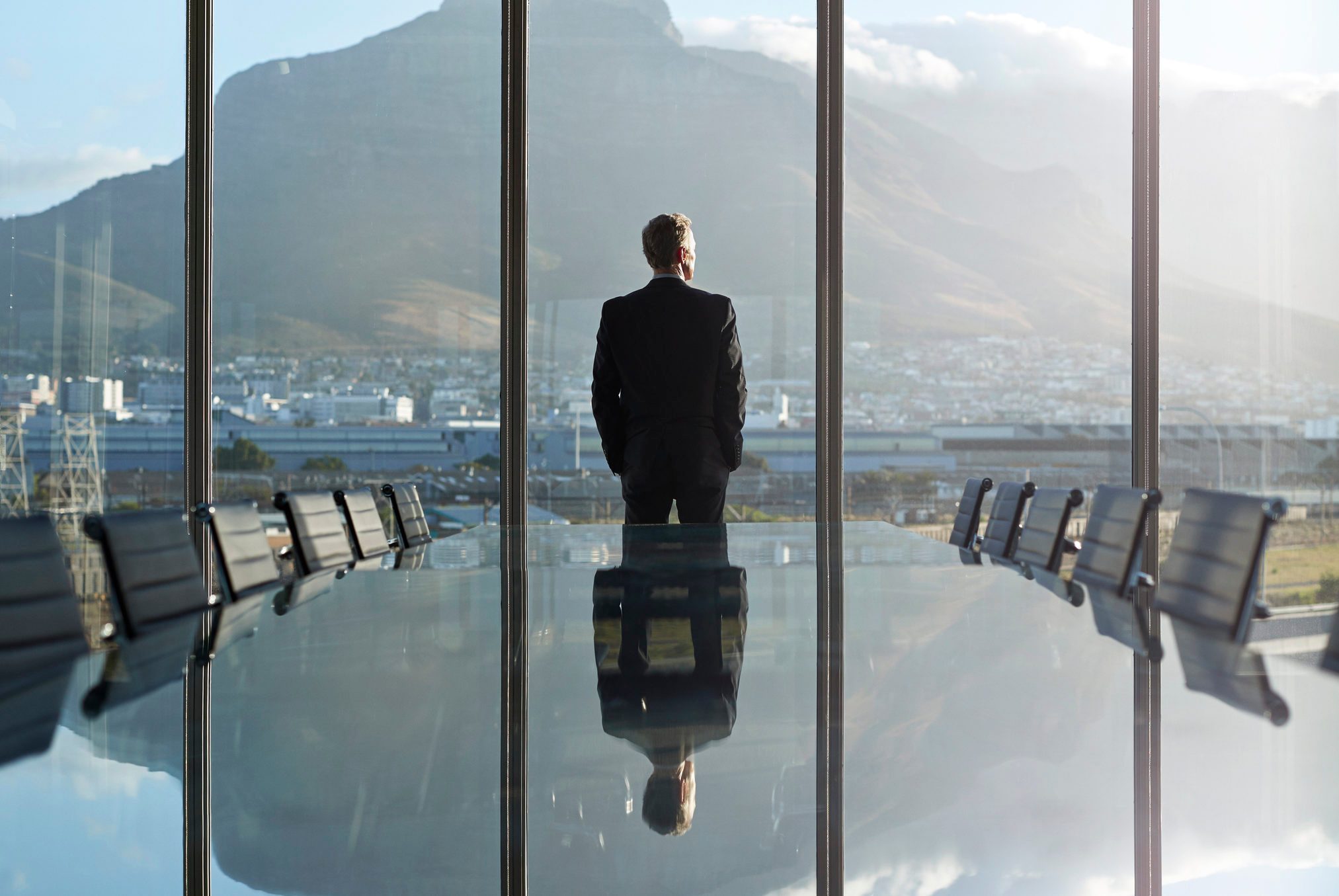 Portrait of male CEO in big corner office, looking out of window