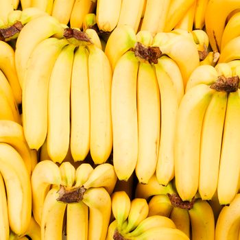 Bananas are grouped closely together, overlapping in a dense arrangement, creating a vibrant yellow pattern.