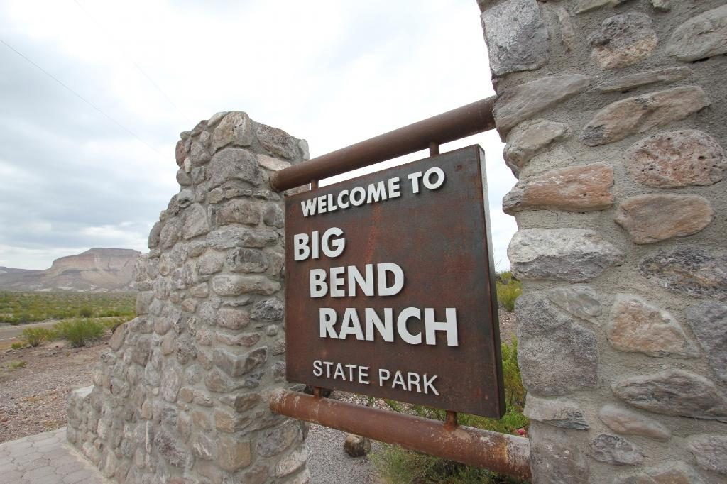 Sign welcomes to "Big Bend Ranch State Park," set against a rocky stone pillar, with desert landscape in the background.