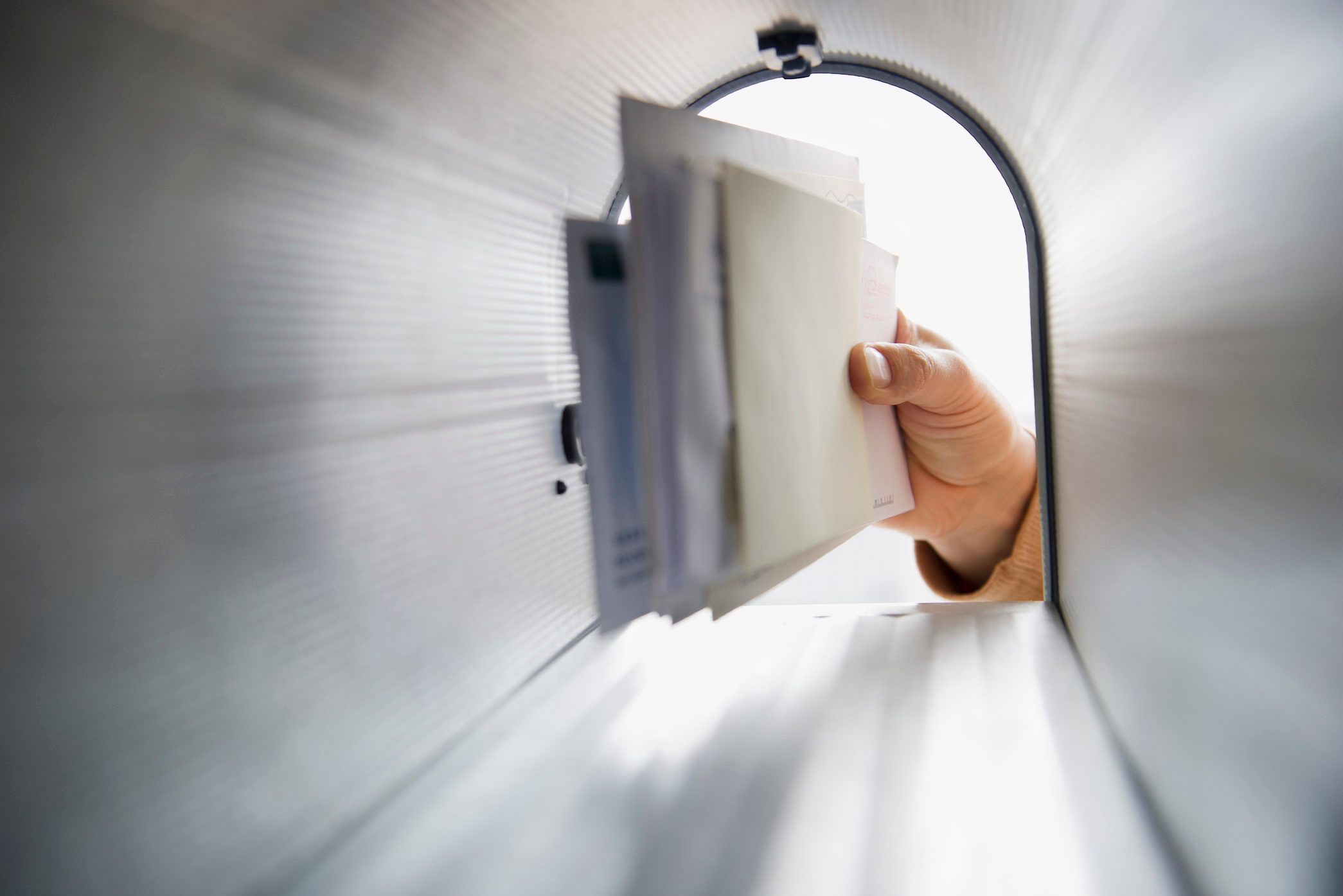 Close-up of man's hand removing letters from letter box
