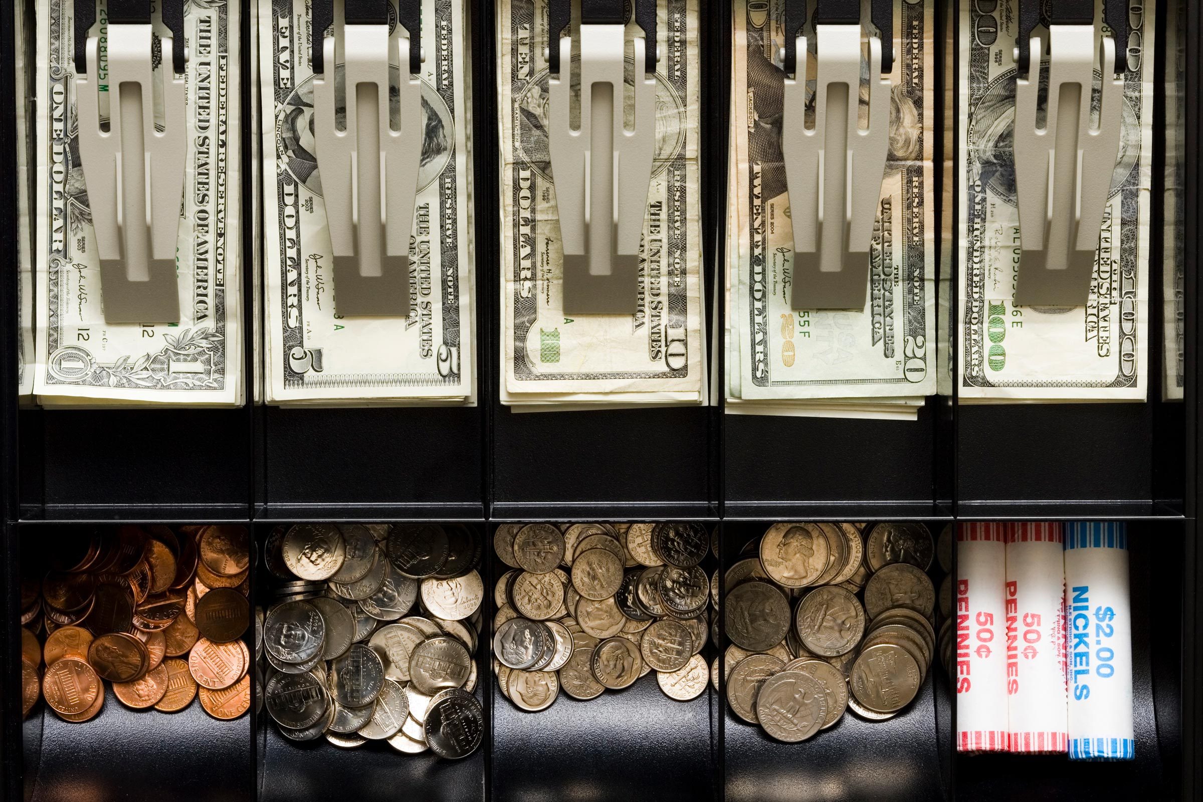 cash and coins in open cash register drawer from above