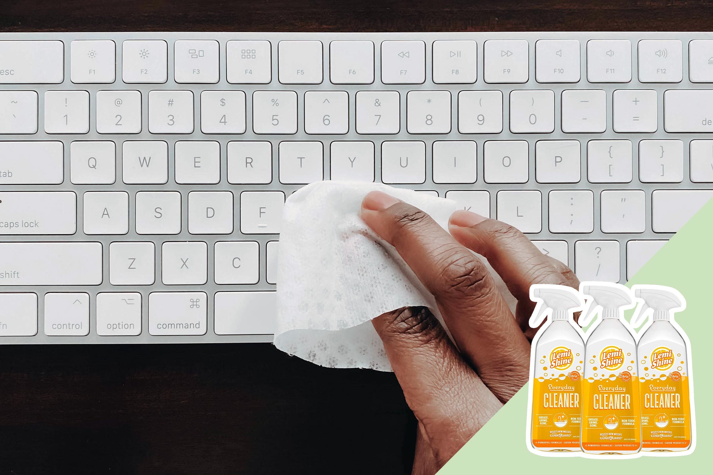 Hand cleans white keyboard with a cloth; three bottles of Lemi Shine Everyday Cleaner are displayed on the right side.