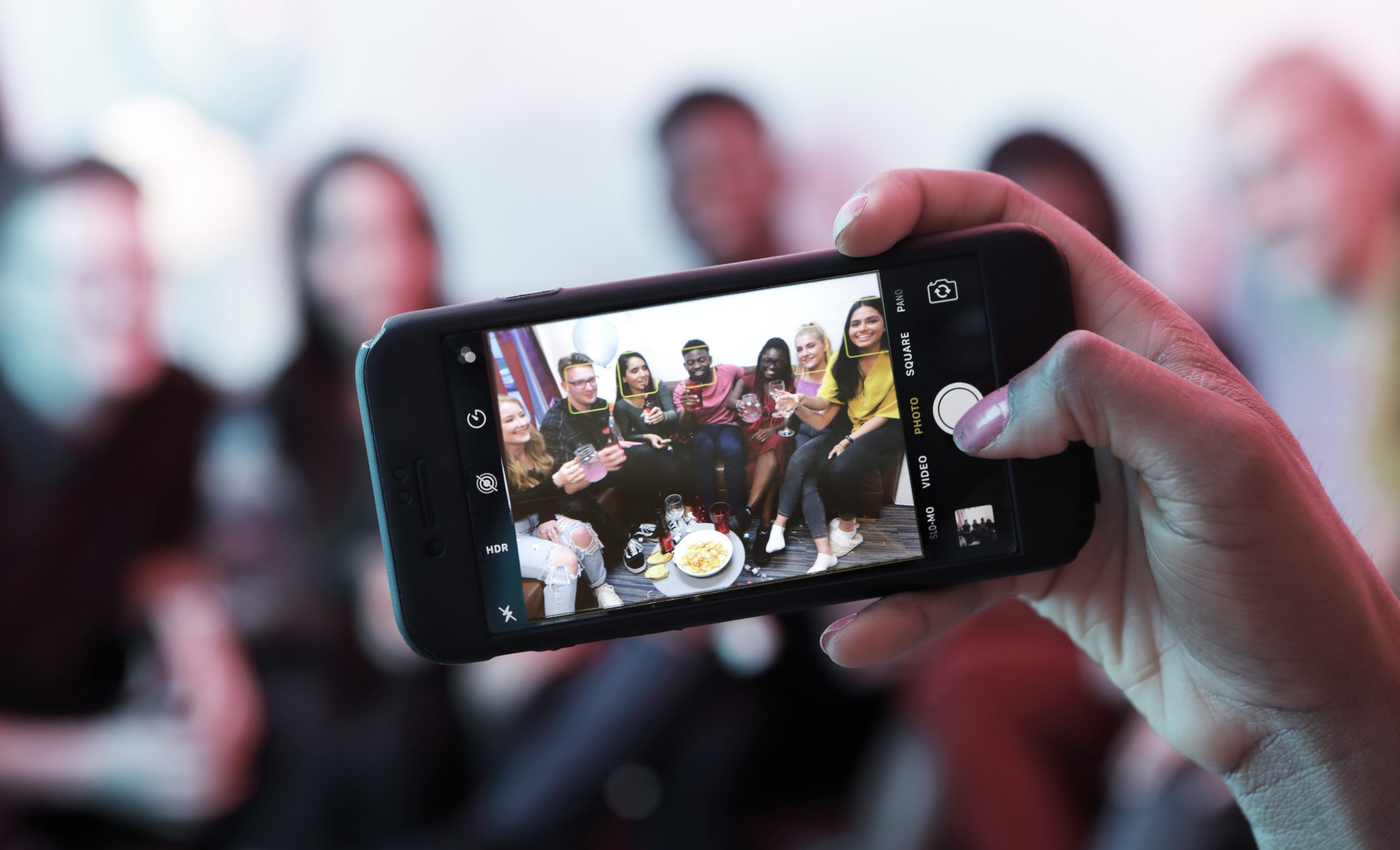 Taking photo of young people at house party