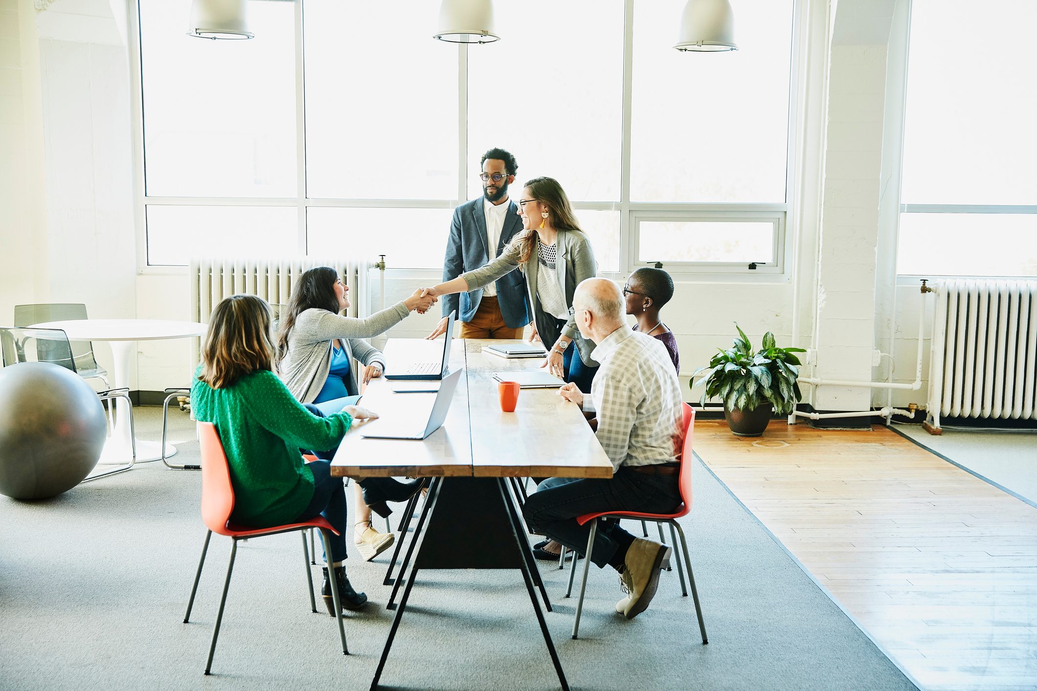 Businesswoman shaking hands with client during meeting in office conference room
