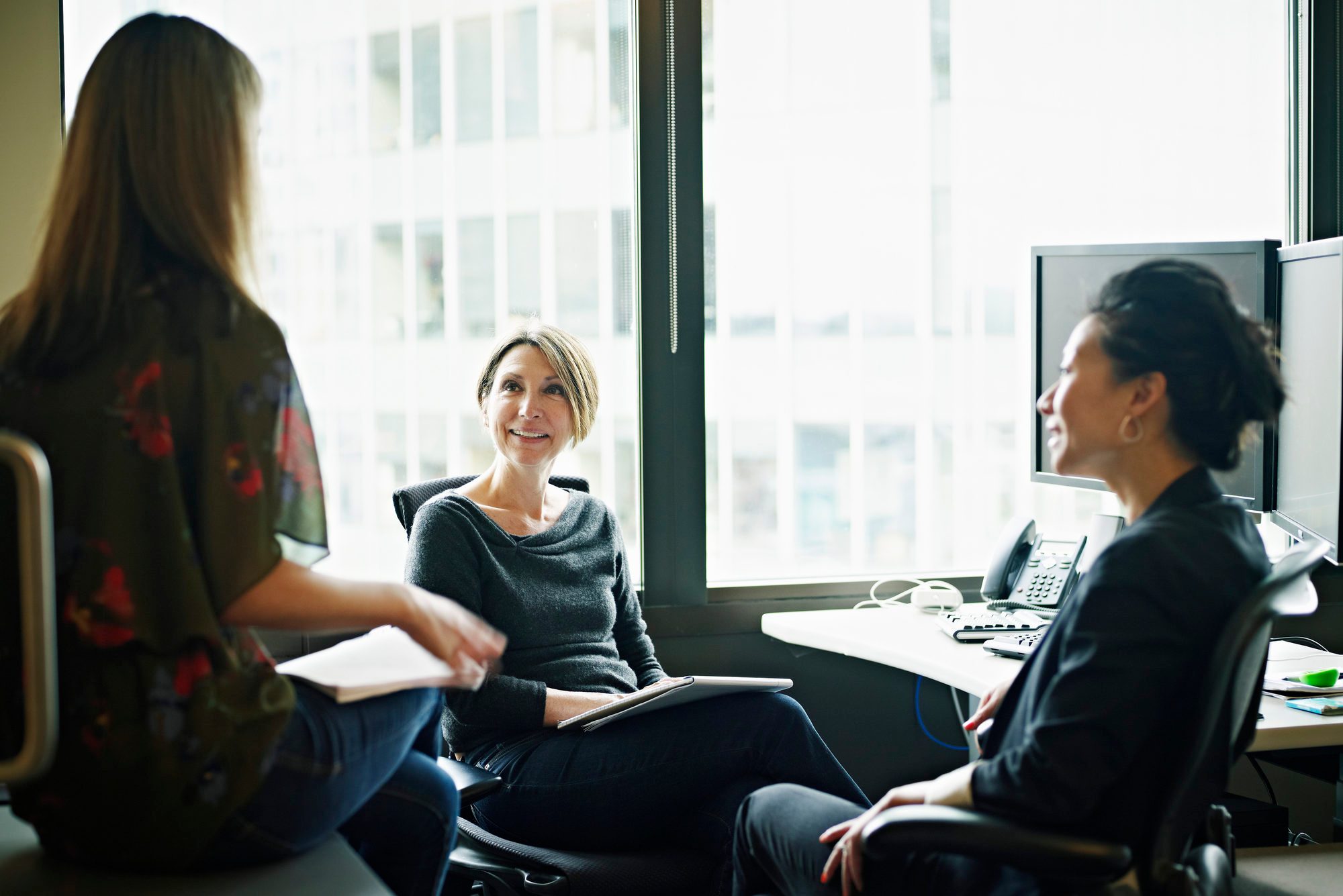Coworkers sitting at workstation in discussion