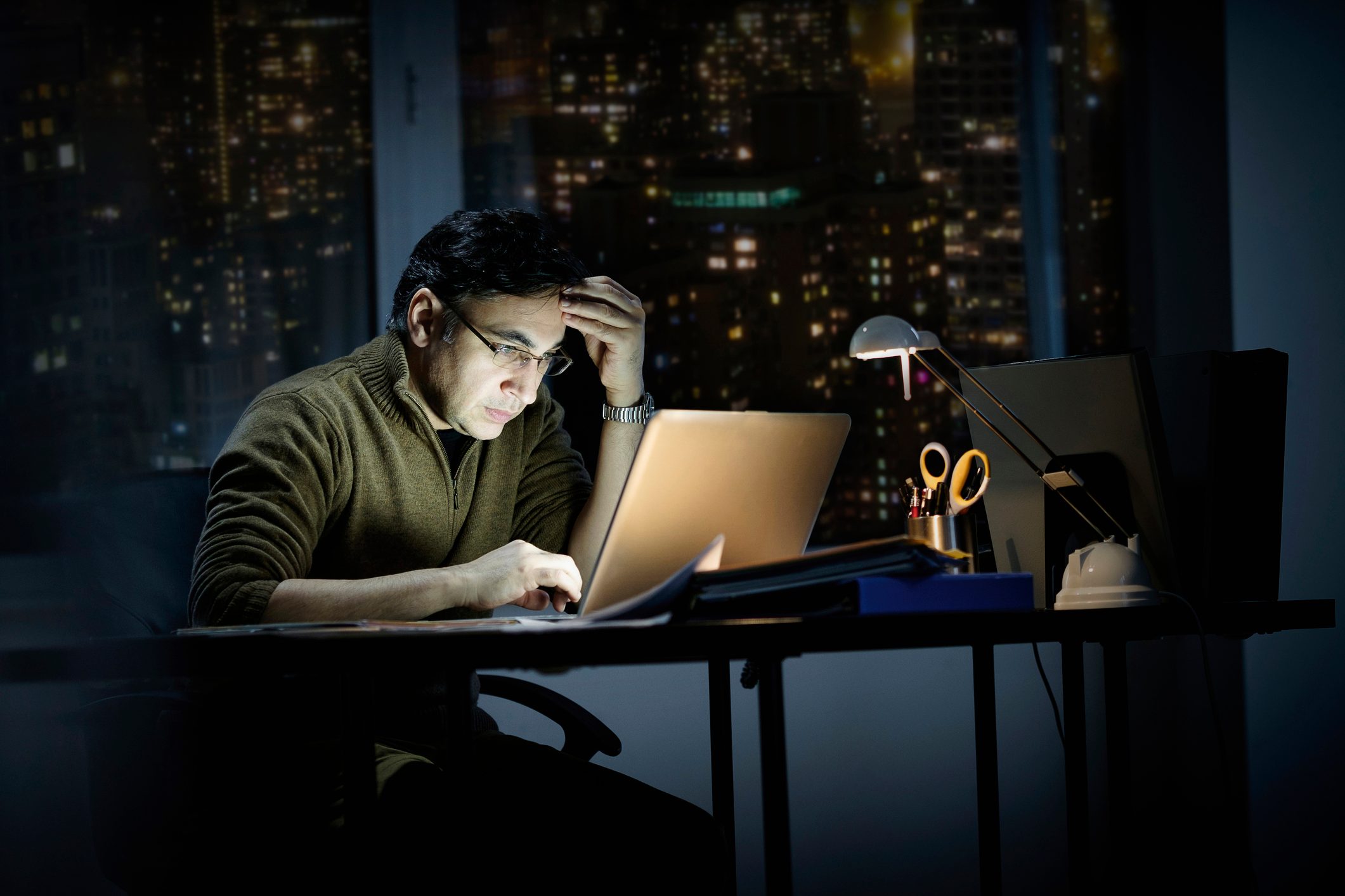 Mixed race businessman working late in office
