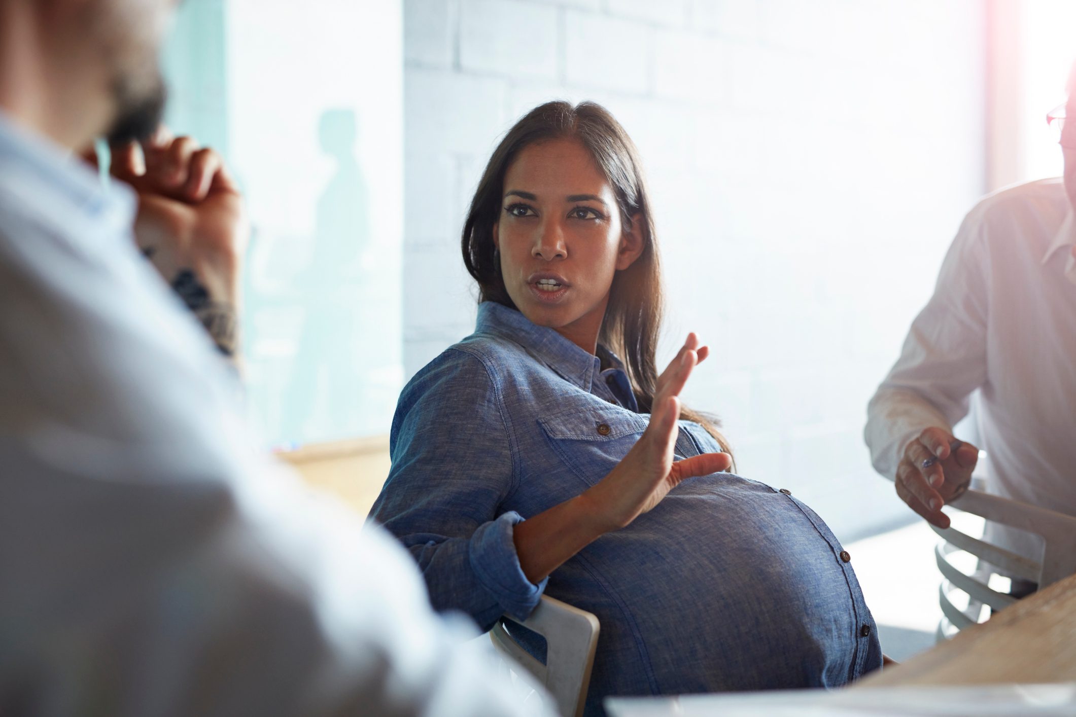 Pregnant woman explaining to co-worker